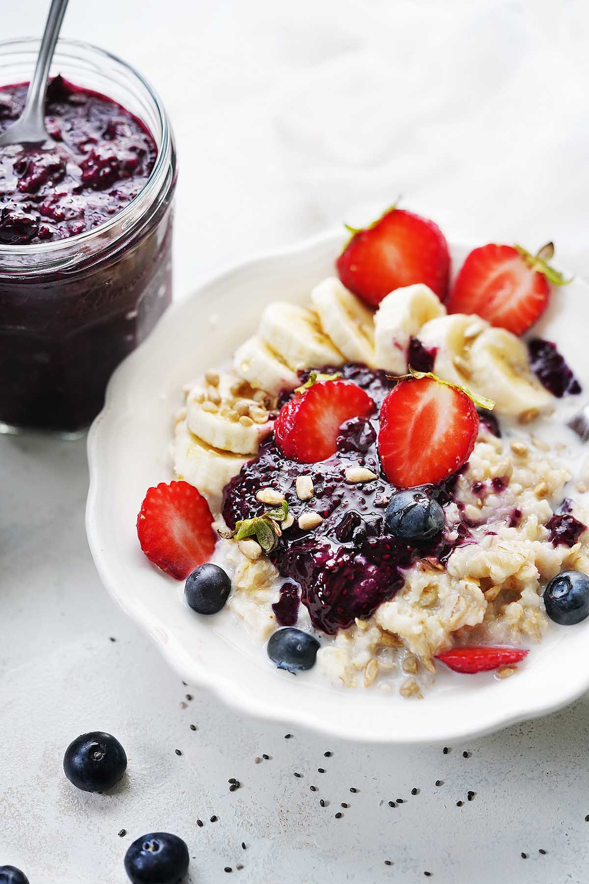 A bowl with oatmeal topped with fruits and chia jam.
