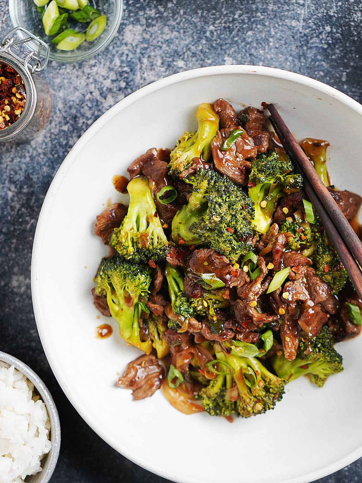 Cooked beef & broccoli stir fry in a bowl on a dark table background.