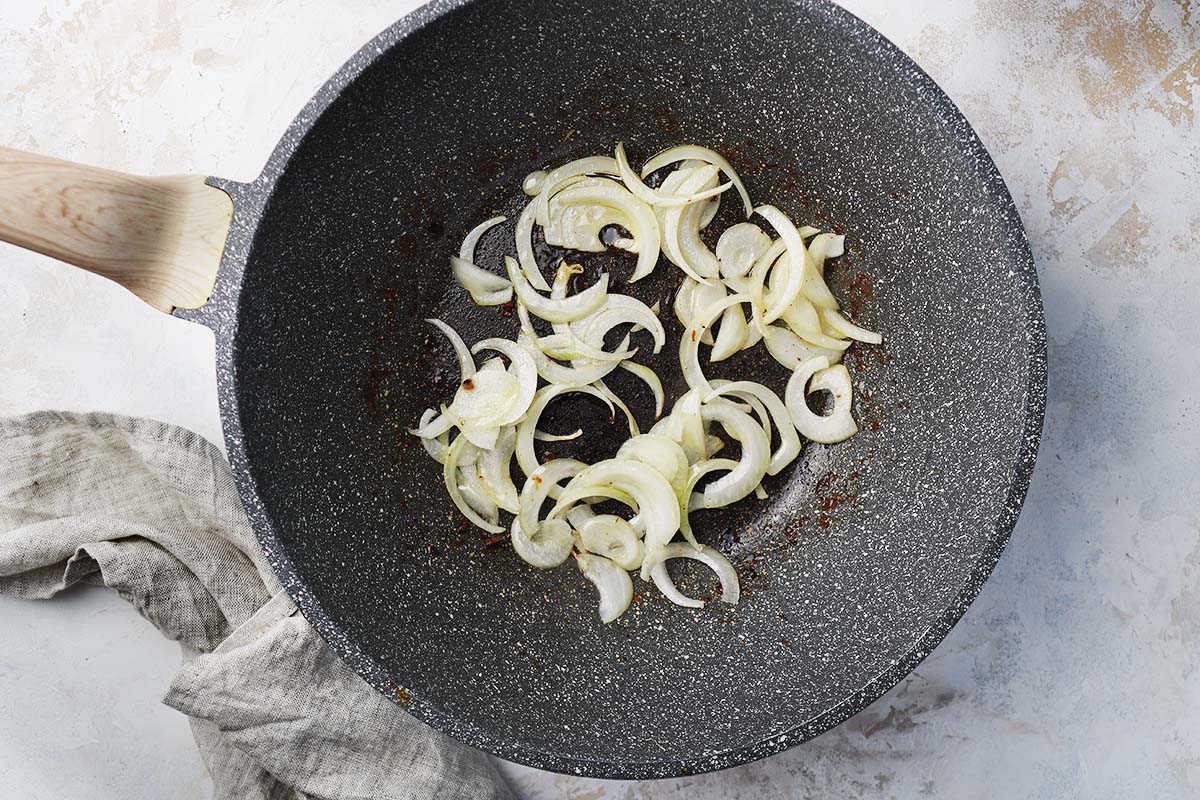 Stir frying onions in a wok.