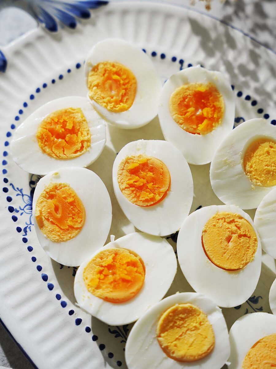 Hard boiled eggs on a white oval plate.