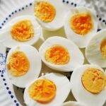 Hard boiled eggs on a white oval plate.
