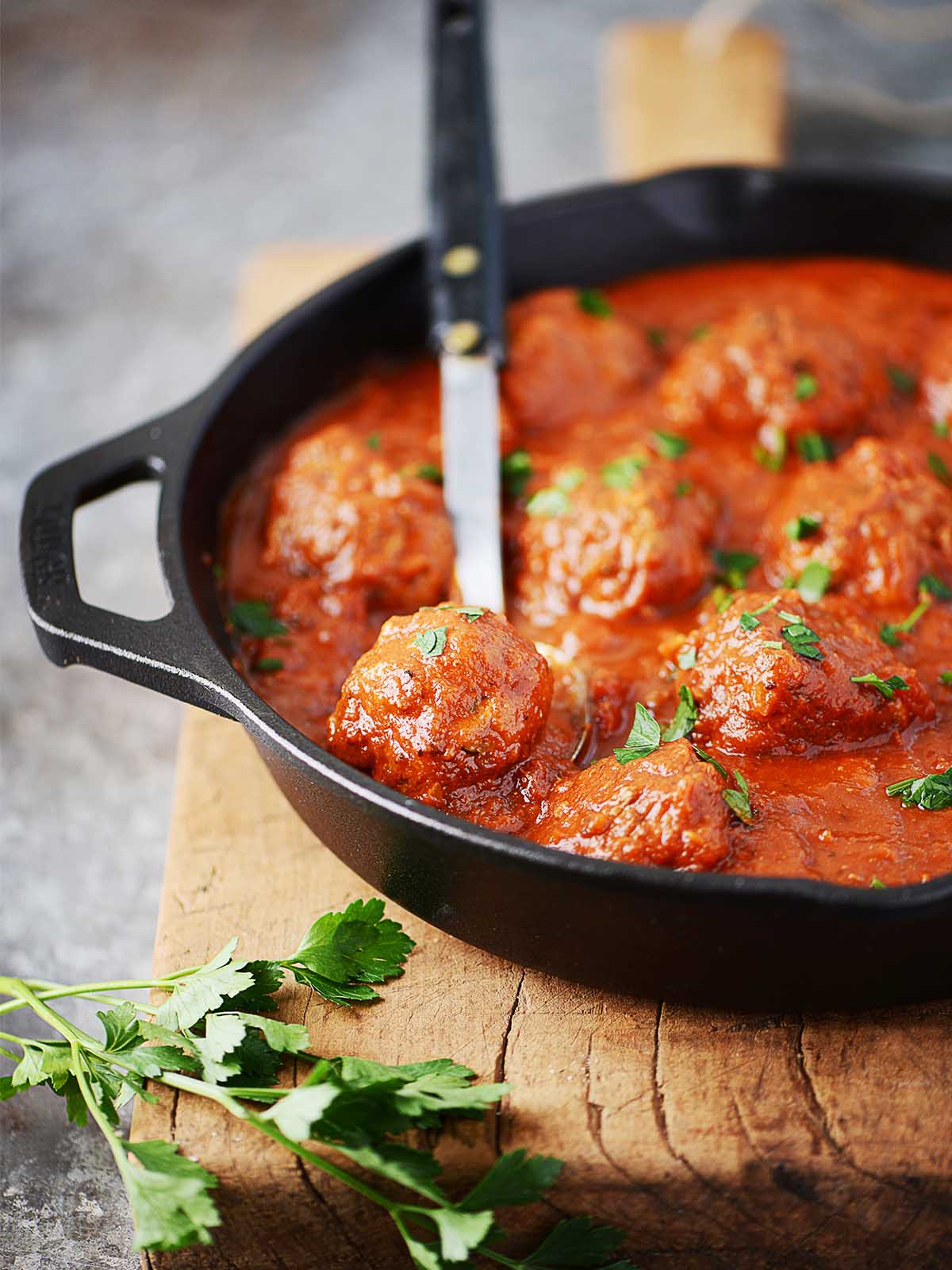 Beef meatballs in a skillet with marinara sauce.