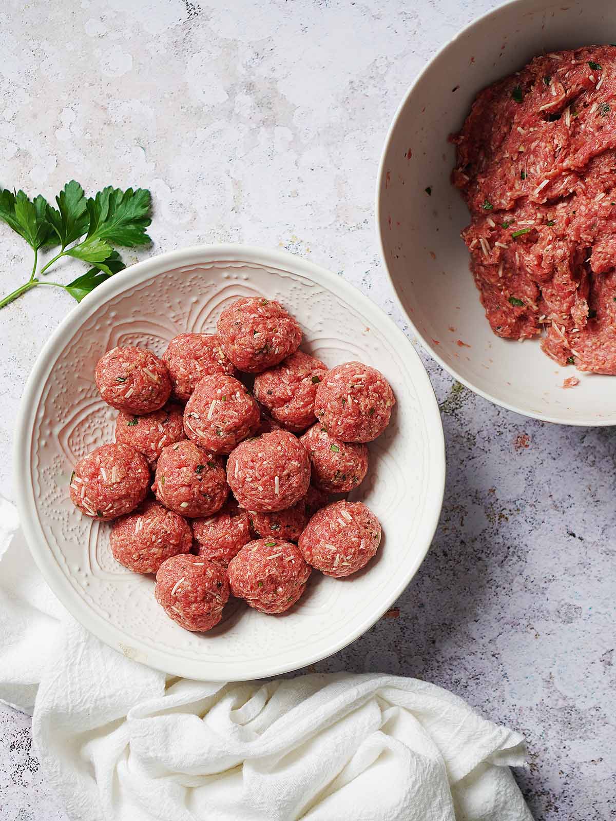 A bowl with raw meatballs.